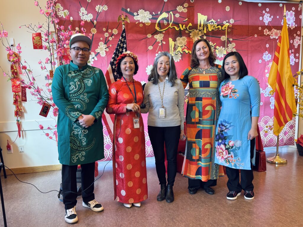 Five people dressed in traditional Vietnamese clothing celebrating Tet