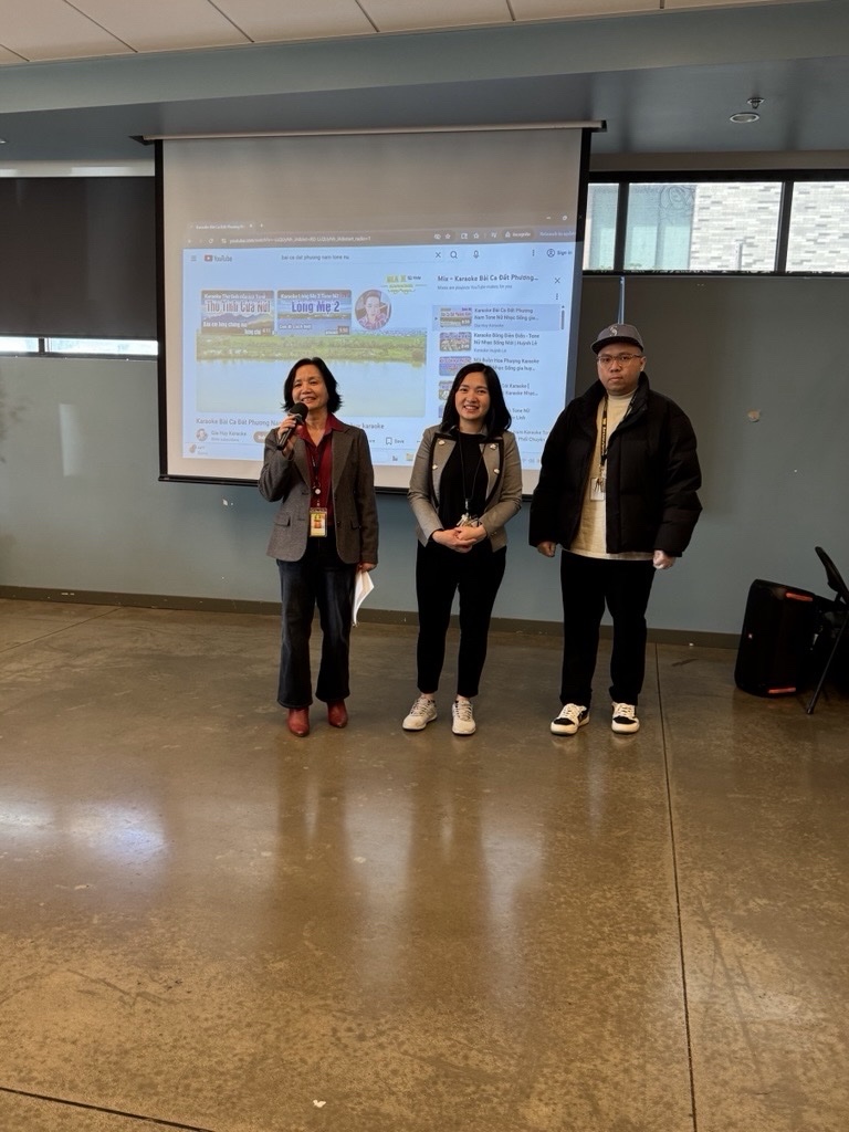 Three people standing in front of a screen presentation